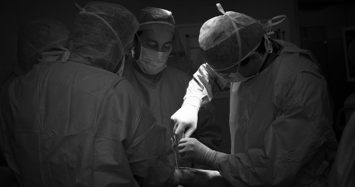 Fotografia medico scientifica: équipe chirurgica durante un intervento in sala operatoria